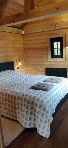 Cette chambre en bois comprend un grand lit. dans l'établissement Chalet Duras, à Saint-Trond