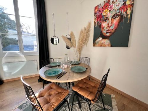 a dining room table with chairs and a painting on the wall at Le Belleville, proche hypercentre au calme, wifi in Nantes