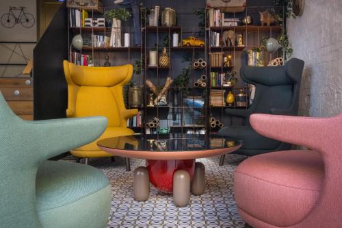 a room with colorful chairs and a table and chairs at Hotel Mirador de Chamartín in Madrid