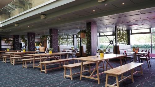 a restaurant with wooden tables and chairs and windows at Comfort Hotel Malmö in Malmö