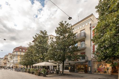 a street in a city with trees and buildings at Meran Center in Merano