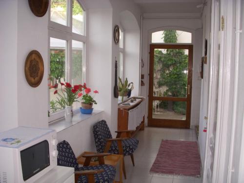 a living room with a tv and chairs and a door at Garden Szivárvány utcai Vendégház in Szeged