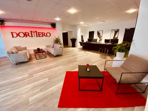 a living room with couches and a red rug at DORMERO Hotel Bretten in Bretten
