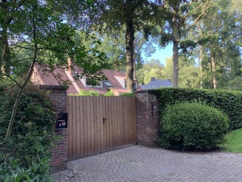 a wooden gate in front of a house at 't Greefsch Geluck in Kalmthout