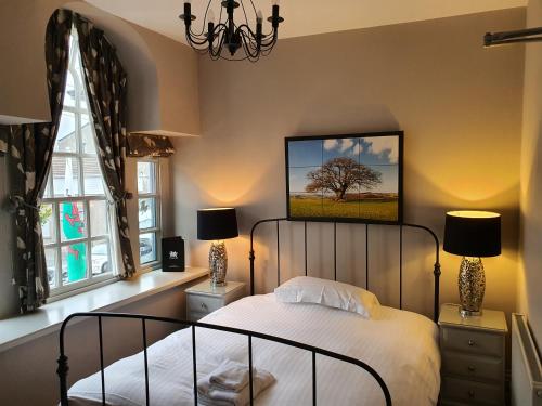 a bedroom with a bed and two windows at Dragon Inn in Crickhowell