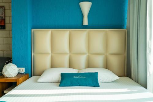 a bedroom with a bed with a blue wall at Villa Edelweiss in Sveti Stefan