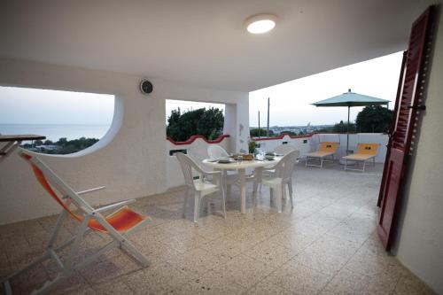 a white dining room with a table and chairs at Villa Laura Salento in Marina di Pescoluse