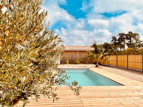- une piscine dans une arrière-cour avec une clôture dans l'établissement VillasHomeClet - Villa Palm Beach, à Vensac