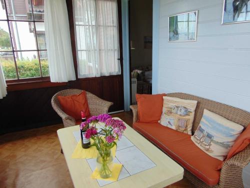 een woonkamer met een bank en een tafel met bloemen bij Strandvilla Whg 01 in Bansin