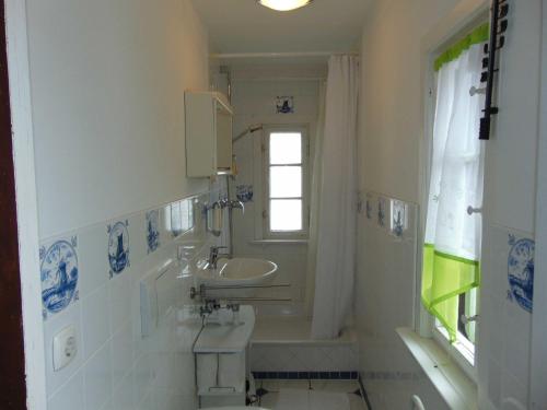 een badkamer met een wastafel, een toilet en een raam bij Strandvilla Whg 01 in Bansin