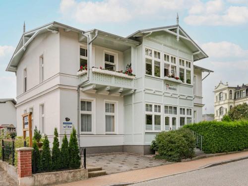 ein weißes Haus mit Blumen auf den Balkonen in der Unterkunft Villa Fichtenhain Whg. 02 in Bansin