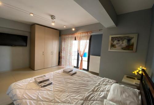 1 dormitorio con 1 cama grande y 2 toallas. en Prosilio Apartment en Tesalónica