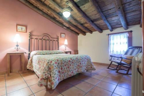 a bedroom with a bed and a chair at Casas Rurales Noguericas in Archivel