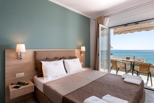 sypialnia z łóżkiem i widokiem na ocean w obiekcie Hotel Dimitra w mieście Ligia