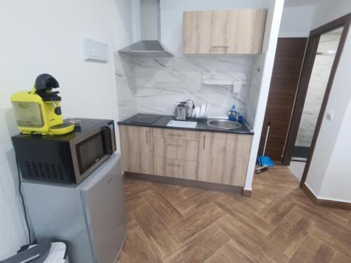 a small kitchen with a microwave and a sink at Apartamento de lujo en la Sierra in Becerril de la Sierra