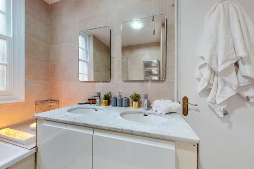 a bathroom with a sink and a mirror at Park Lane Apartments - Clarges Street in London