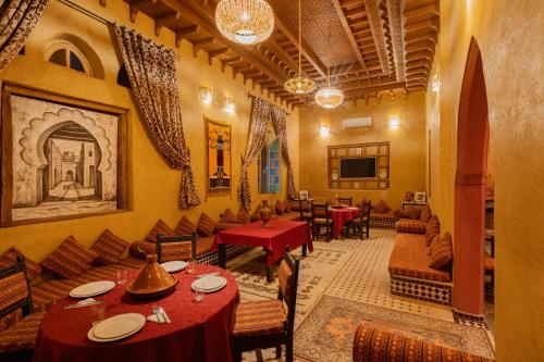 a restaurant with tables and chairs in a room at Kasbah Hotel Ziz Palace Rissani in Rissani