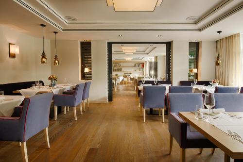 a dining room with tables and blue chairs at Hotel Tandreas in Gießen