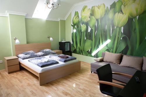 a bedroom with a bed and a flower mural at Hunyadi Panzió-Apartman in Makó