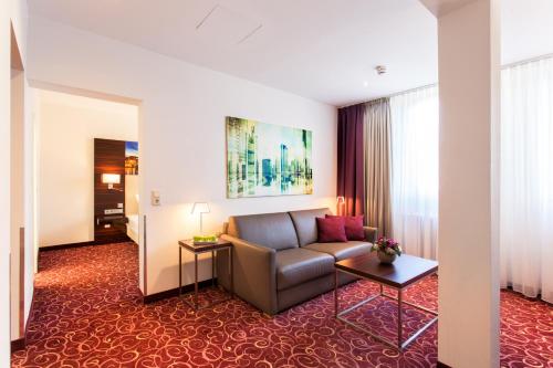 a living room with a couch in a hotel room at The Domicil Hotel Frankfurt City in Frankfurt/Main