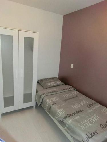 a small bedroom with a bed and a cabinet at lovely propertys in Bucharest