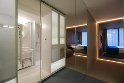 een badkamer met een glazen douche en een slaapkamer bij Hotel Katarina in Selce