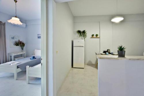 Roberto's Apartments في رودا: مطبخ وغرفة معيشة مع ثلاجة وطاولة