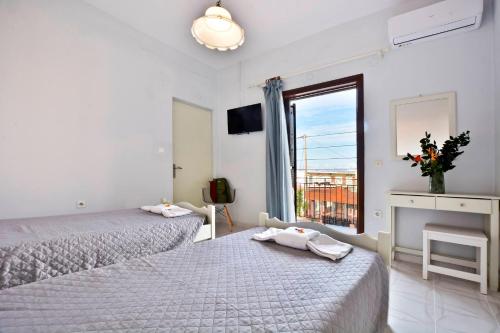 Roberto's Apartments في رودا: غرفة نوم بسريرين ومدفأة ونافذة