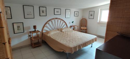1 dormitorio con 1 cama y cuadros en la pared en Casa Vacanze Varuga, en Praia a Mare