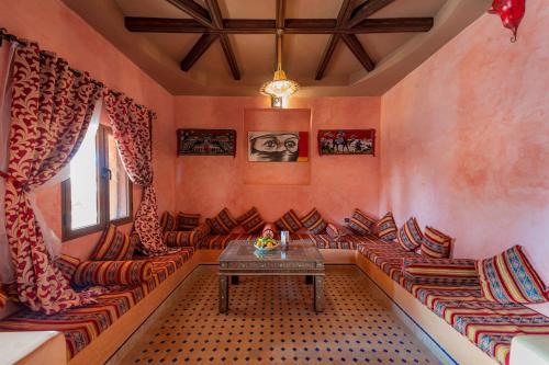 a living room with couches and a table at Kasbah Hotel Ziz Palace Rissani in Rissani