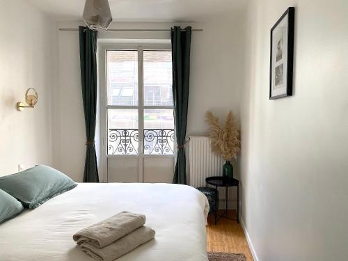 une chambre avec un lit avec deux serviettes dessus dans l'établissement My Trip in Paris - Temple, à Paris