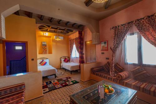 a room with a bedroom with a bed and a couch at Kasbah Hotel Ziz Palace Rissani in Rissani