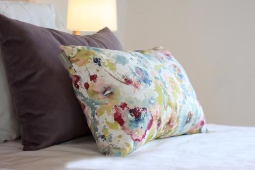 a colorful pillow sitting on a bed with two pillows at Quinta da Luz - A Luxury Boutique B&B in Silves