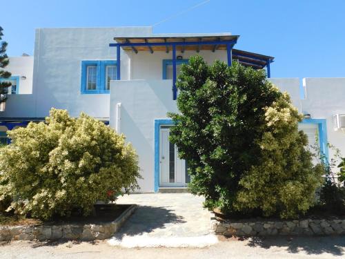 a blue and white house with trees in front of it at Anna Ageliki in Damnoni