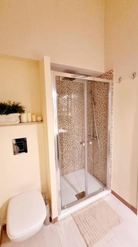 a bathroom with a toilet and a glass shower at Civico 64 in Ortona