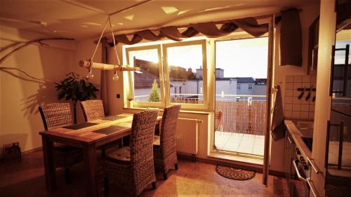 a dining room with a table and chairs and a window at Holzmichel FEWO mit Balkon in Cottbus