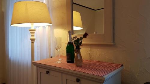 a table with two lamps and a bottle and a wine glass at Landhotel-Restaurant Beckmann in Heiden