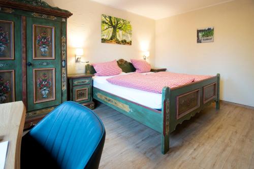 a bedroom with a bed and a blue chair at Landhotel-Restaurant Beckmann in Heiden