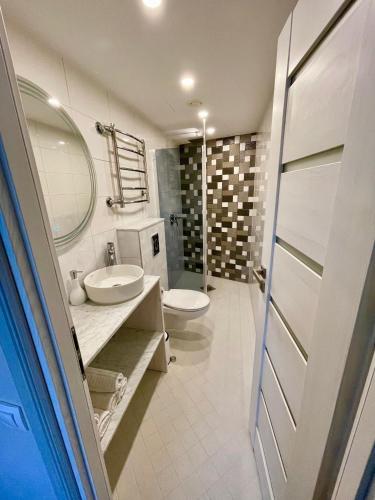 a bathroom with a sink and a toilet and a mirror at Hotel Vesiroos in Pärnu