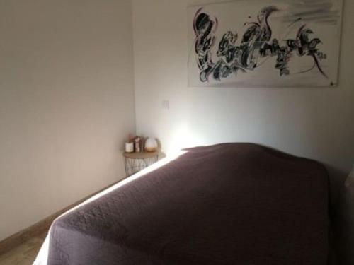 1 dormitorio con 1 cama y una foto en la pared en Petite maison en pierre en Saint-Florent