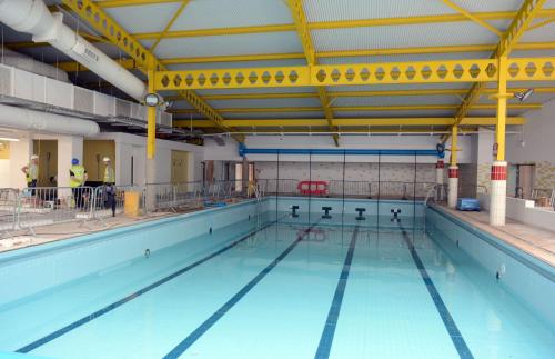 a large swimming pool with blue water at CJ & Daisies Holiday Home in Prestatyn