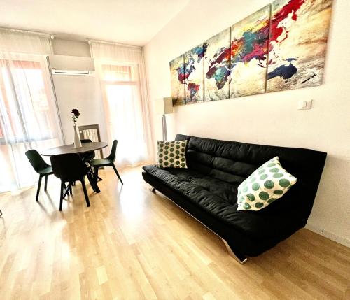 uma sala de estar com um sofá preto e uma mesa em Ale’s House em Veneza-Lido