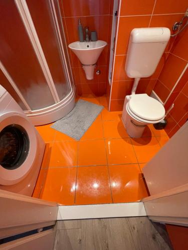奧西耶克的住宿－La bella casa，橙色的浴室设有卫生间和淋浴。
