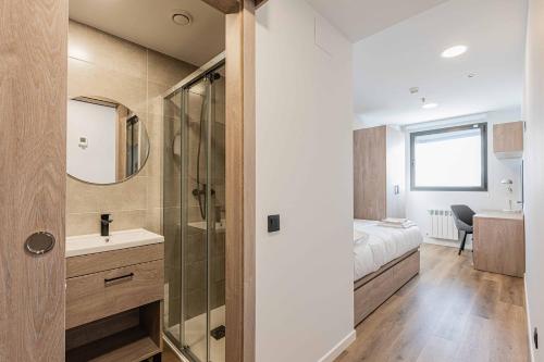 a bathroom with a bed and a sink and a mirror at Micampus Santander Student Residence in Santander