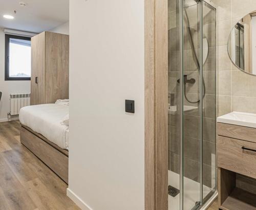uma casa de banho com um chuveiro, um lavatório e uma cama em Micampus Santander em Santander