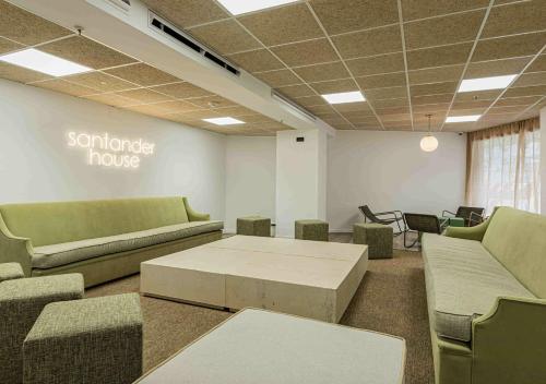 a waiting room with couches and a table and chairs at Micampus Santander Student Residence in Santander
