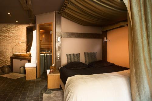 a bedroom with a bed and a bathroom with a sink at Vakantiehuis wellness Oase in Londerzeel