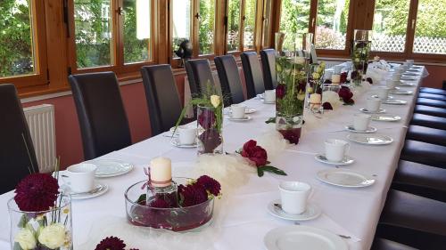 a long table with candles and flowers on it at Hotel Zum Leineweber in Burg