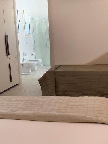 a bedroom with a bed and a bathroom with a sink at Villa Katy Salento in Campomarino