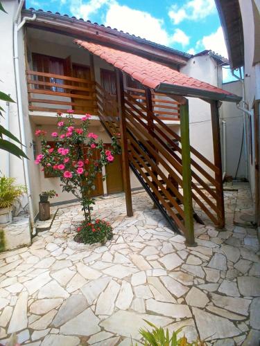 a balcony of a house with flowers on the ground at Hospedaria de Maria in Tiradentes